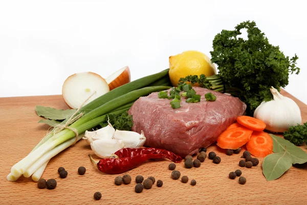 Raw meat, vegetables and spices isolated on a wooden table. — Stock Photo, Image