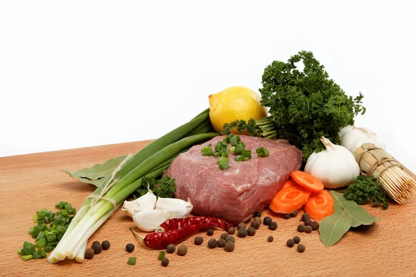 Çiğ et, sebze ve ahşap bir masaya izole baharat. — Stok fotoğraf