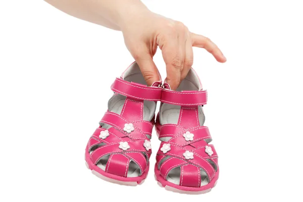 Pink Children 's sandals in the women' s hands isolated on white . — стоковое фото