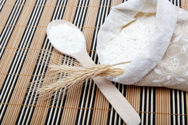 Harina y grano de trigo con cuchara de madera sobre una mesa de madera . —  Fotos de Stock