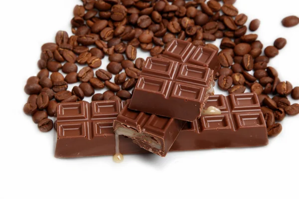 Chocolate y granos de café sobre un fondo blanco . — Foto de Stock