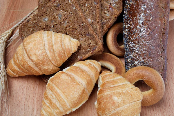 Assortiment van gebakken goederen in hout achtergrond — Stockfoto