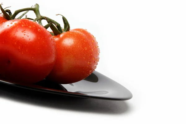 Fresh tomatoes on a plate, isolated on a white background. — Stock Photo, Image