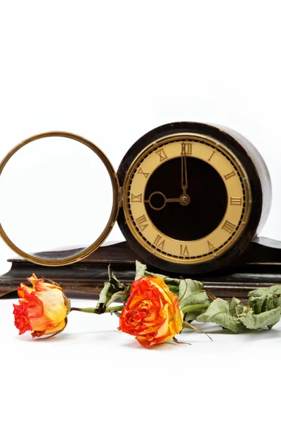 Rose secche e antico orologio da tavolo in legno su sfondo bianco . — Foto Stock