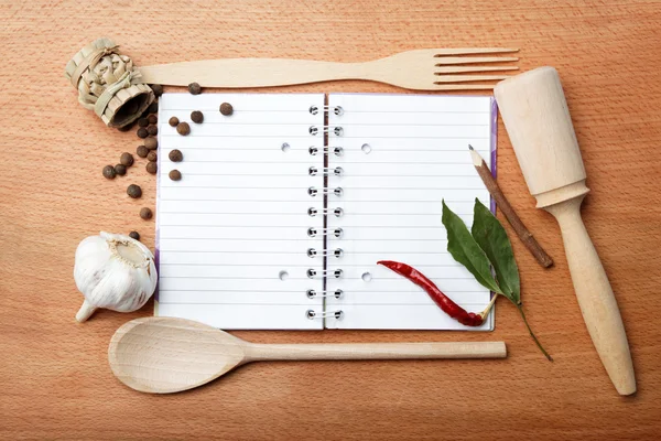Caderno de receitas e especiarias em mesa de madeira — Fotografia de Stock