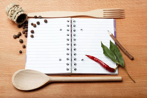 Ноутбук для рецептов и специй на деревянном столе — стоковое фото