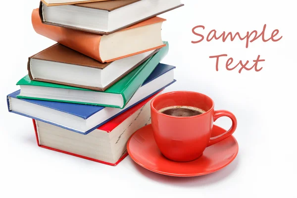 En trave böcker och en kopp kaffe i ett fat på en vit baksida — Stockfoto