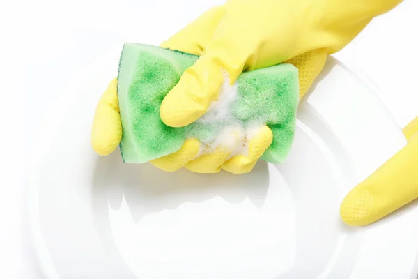 Hands in rubber gloves can sponge the plate on a white backgroun — Stock Photo, Image