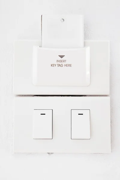 Interruptor de luz y etiqueta clave en blanco en la pared — Foto de Stock