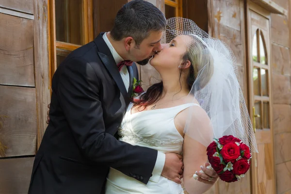 Csak feleségül vette a fiatal pár csókolózás, a ház előtt — Stock Fotó