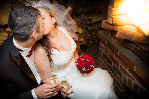 Szczęśliwi nowożeńcy para siedząc przed kominkiem — Zdjęcie stockowe