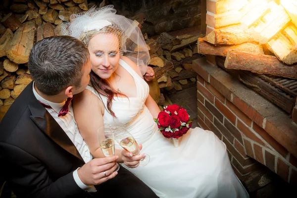 Pareja joven celebrando el matrimonio frente a la chimenea — Foto de Stock