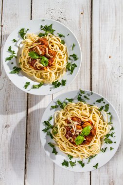 Spaghetti for two seasoned with fresh spices clipart