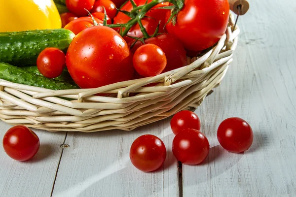 Close-up van verse tomaten en fruit in een mand — Stockfoto