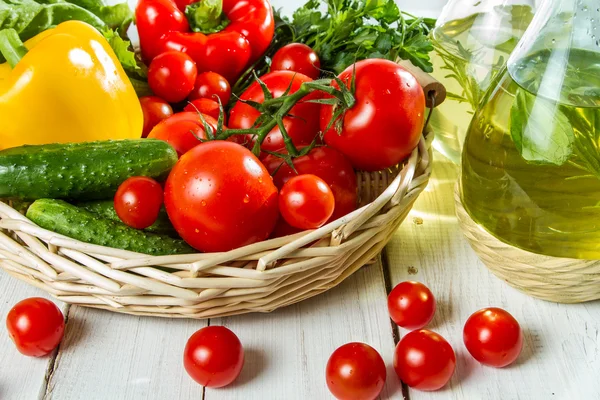 Verduras en una cesta y aceite de oliva — Foto de Stock