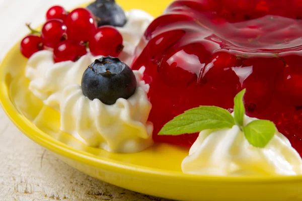 Красное желе подается на тарелке с ягодами — стоковое фото