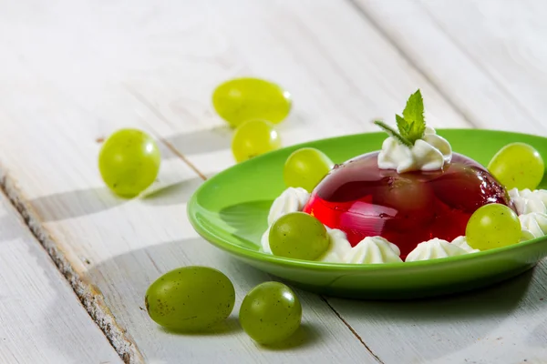 Red jelly and grapes served on a plate — Stock Photo, Image