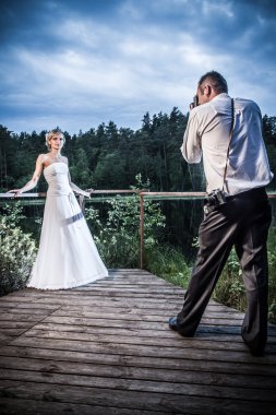 Groom takes a picture of the bride clipart