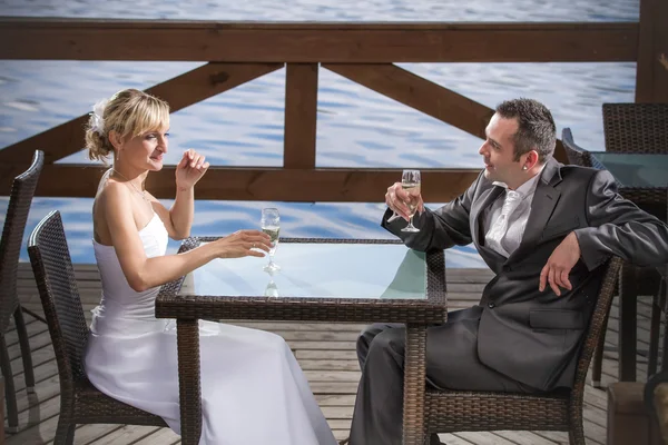 O noivo e a noiva estão comemorando com champanhe — Fotografia de Stock