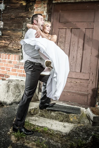 Glücklicher Bräutigam bringt die Braut ins Haus — Stockfoto