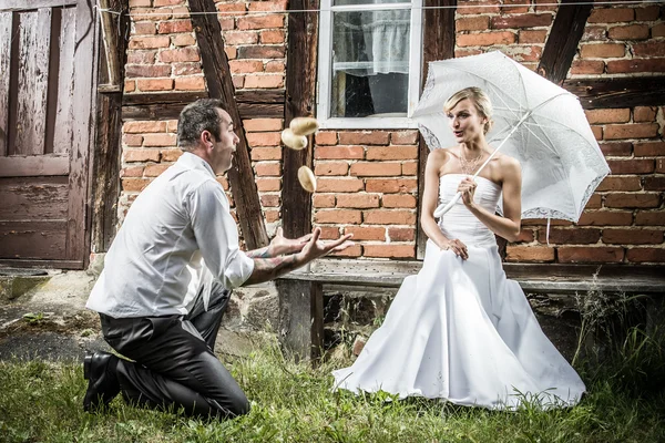 The bride and groom looking at juggling potatoes — Stock Photo, Image