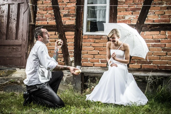 Brudgummen jonglering potatis — Stockfoto