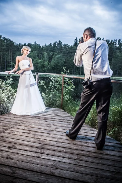 Bruden och brudgummen fotosession i parken vid sjön — Stockfoto