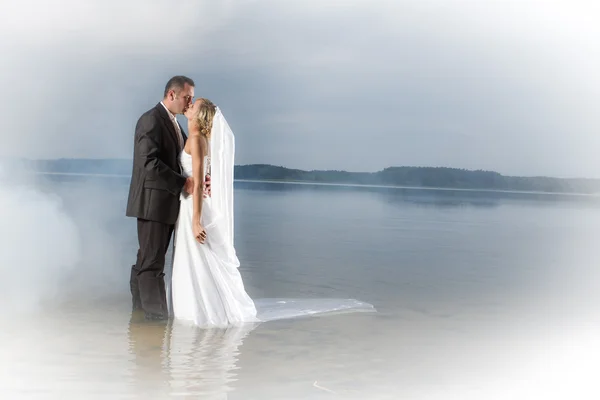 Young couple kissing by the lake — Stock Photo, Image