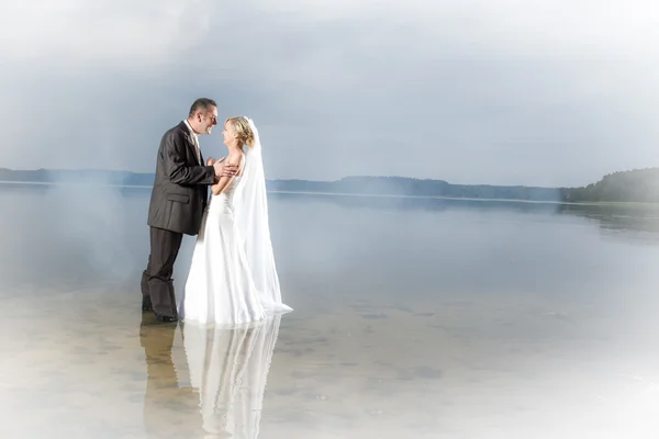 Young couple in the fog on the lake — Stock Photo, Image