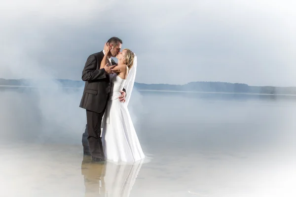 Appena sposati giovane coppia in un lago nebbioso — Foto Stock