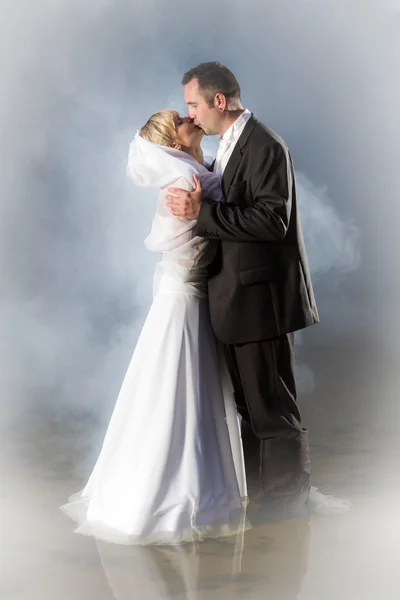 Jovem casal beijando em um lago nebuloso — Fotografia de Stock