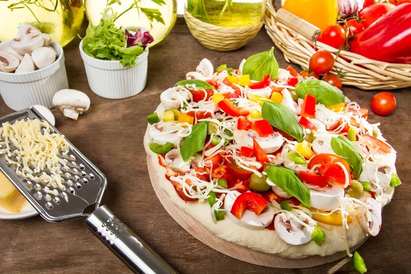 Пицца перед выпечкой из свежих овощей — стоковое фото