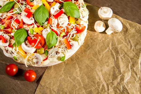 Primer plano de pizza fresca acostada en el papel de hornear —  Fotos de Stock