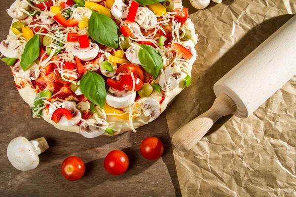 Rolling pin and fresh pizza — Stock Photo, Image
