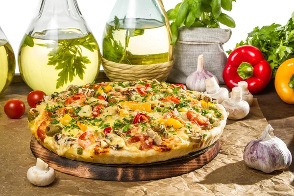 Gebakken pizza en flessen van olijfolie — Stockfoto