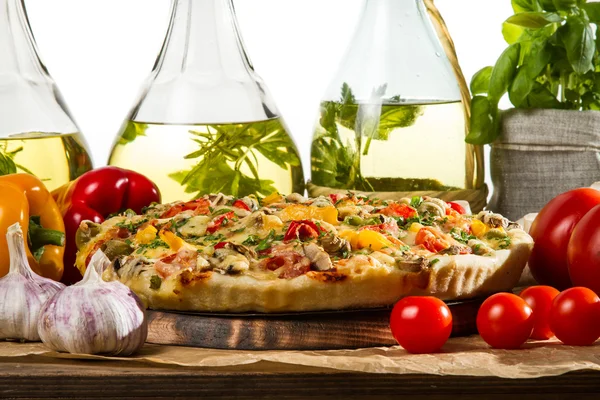 Closeup of baked pizzas on the background of bottles of olive oi — Stock Photo, Image