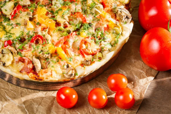 Close-up of fresh tomatoes and baked pizzas — Stock Photo, Image