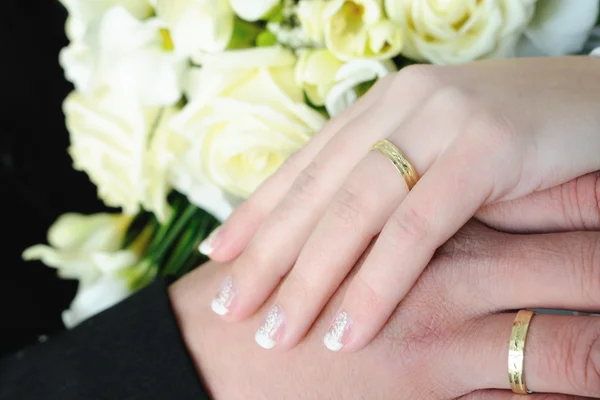 Svatební ruce a zlaté prsteny — Stock fotografie