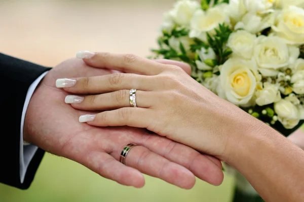 Bruiloft handen en gouden ringen — Stockfoto