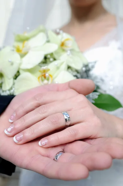 Bruiloft handen en gouden ringen — Stockfoto