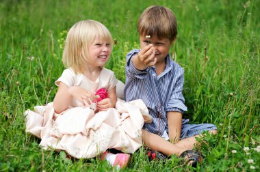 Portret van schattige kinderen zittend op groen gras