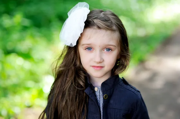 Menina bonito com arco branco em seu cabelo — Fotografia de Stock