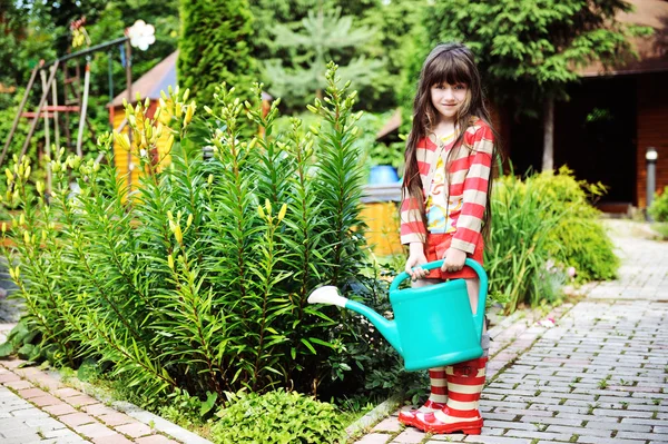 Menina em um jardim com regador verde pode — Fotografia de Stock