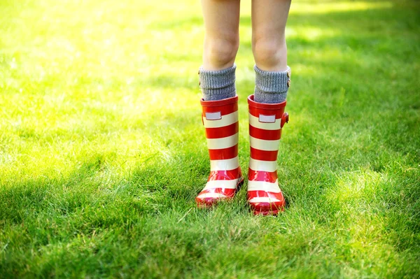Image of child legs wearing red rain boots — Stock Photo, Image