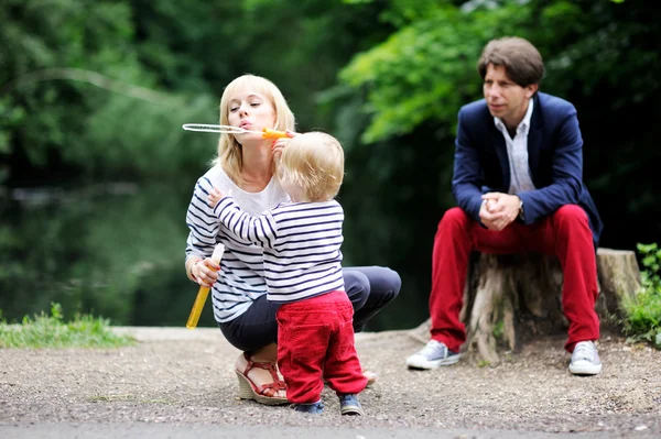 Счастливая семья веселится вместе в парке — стоковое фото
