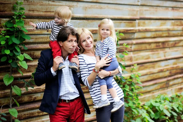Gelukkige ouders met kinderen poseren buitenshuis — Stockfoto