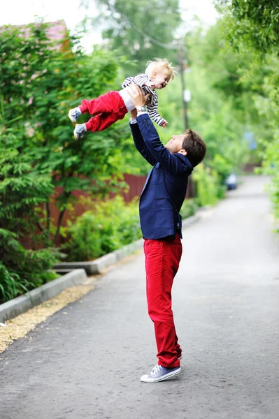 Отец бросает маленького мальчика в воздух — стоковое фото