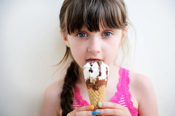 Söt liten flicka med glass i studio — Stockfoto