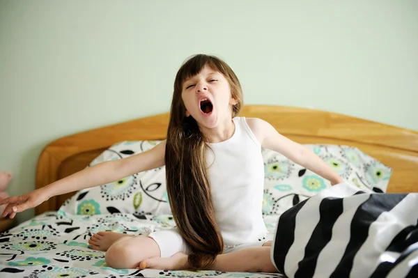 Портрет пробудженої маленької дівчинки, що сидить у ліжку — стокове фото