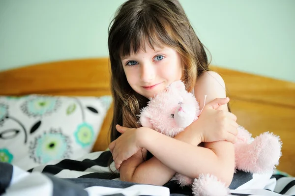 Porträtt av väcka lilla flicka sitter i sängen — Stockfoto